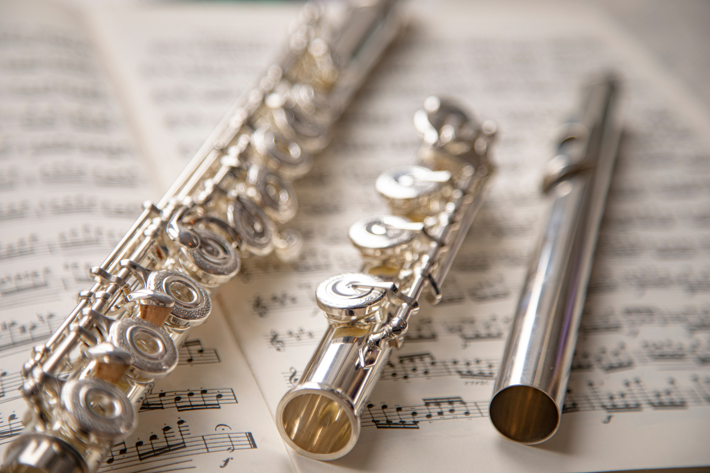 Silver Flutes on Top of a Sheet Music